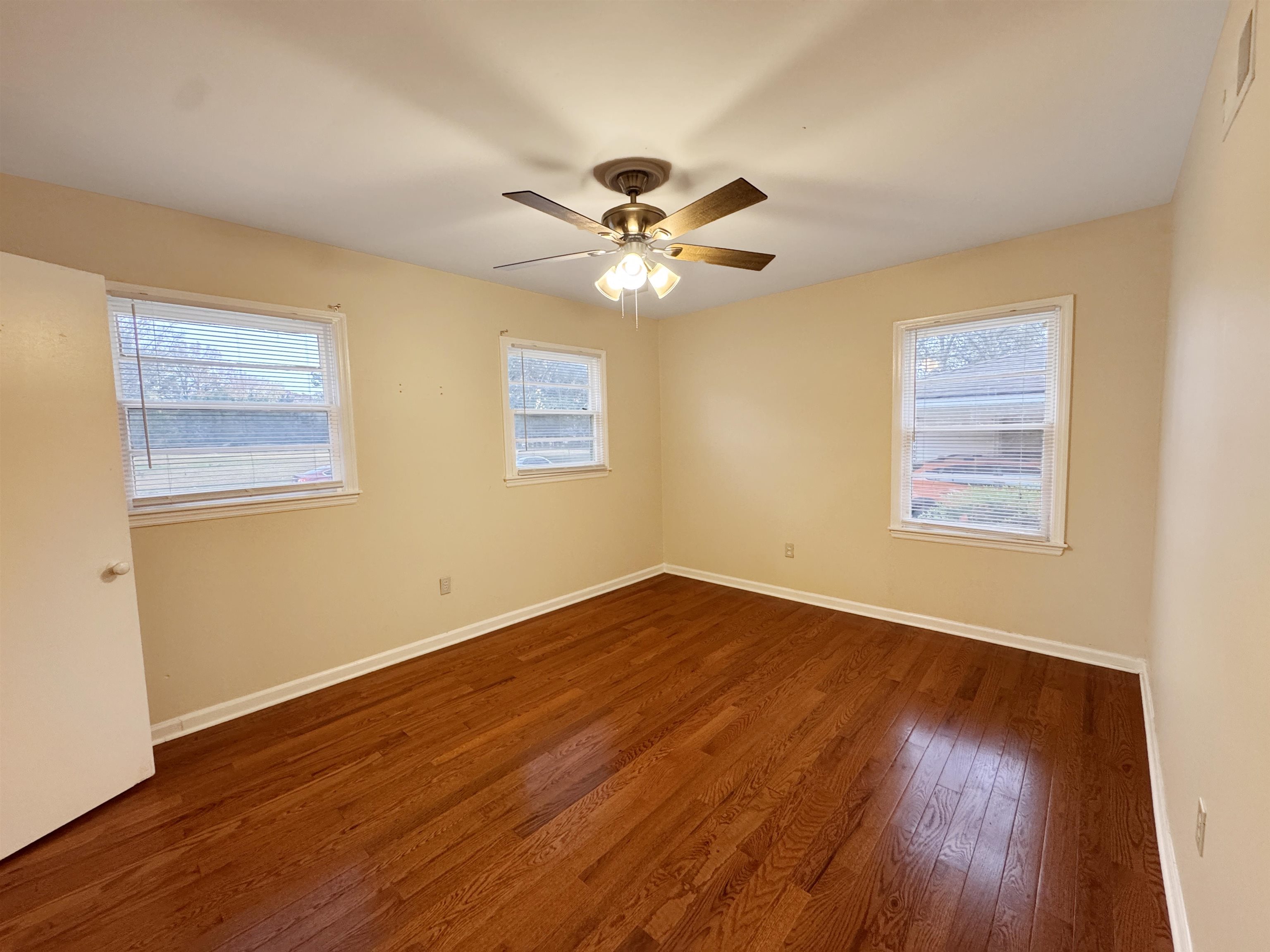 1519 South White Station Road Memphis, TN 38117 - Photo 10 of 31 a view of an empty room with window and wooden floor