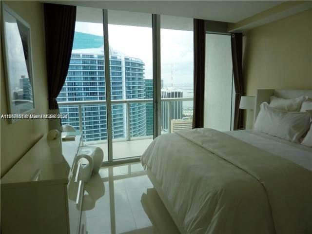 485 Brickell Avenue, Unit 4103 Miami, FL 33131 - Photo 9 of 13 a bed sitting in a bedroom next to a balcony