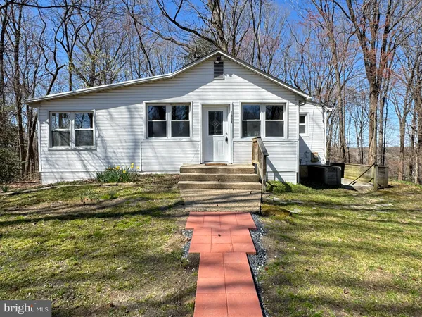 a front view of a house with a yard table and chairs
