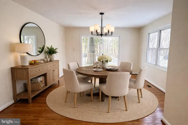 a dining room with furniture a chandelier and wooden floor