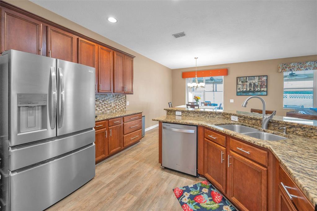 3619 Hatchbend Way Wesley Chapel, FL 33544 - Photo 18 of 86 a kitchen with stainless steel appliances granite countertop a refrigerator sink and wooden cabinets