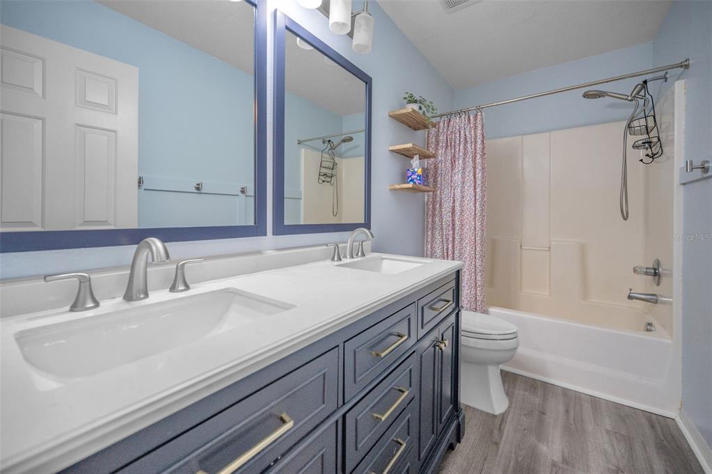 3619 Hatchbend Way Wesley Chapel, FL 33544 - Photo 36 of 86 a bathroom with a granite countertop sink a toilet a mirror and shower