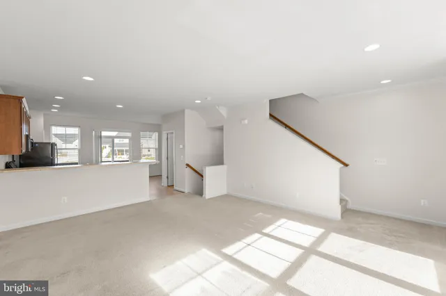 a kitchen with kitchen island granite countertop a stove a sink dishwasher a refrigerator with wooden floor and cabinets