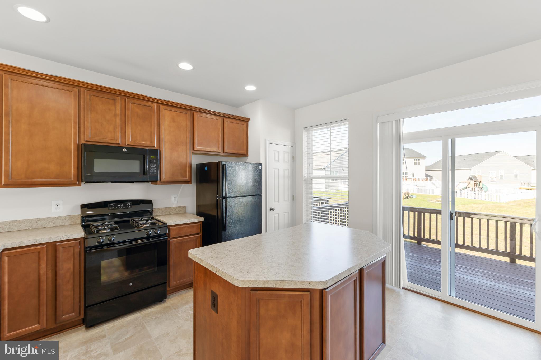 107 Fading Star Court Stephenson, VA 22656 - Photo 25 of 50 a kitchen with kitchen island granite countertop a stove a sink dishwasher a refrigerator with wooden floor and cabinets