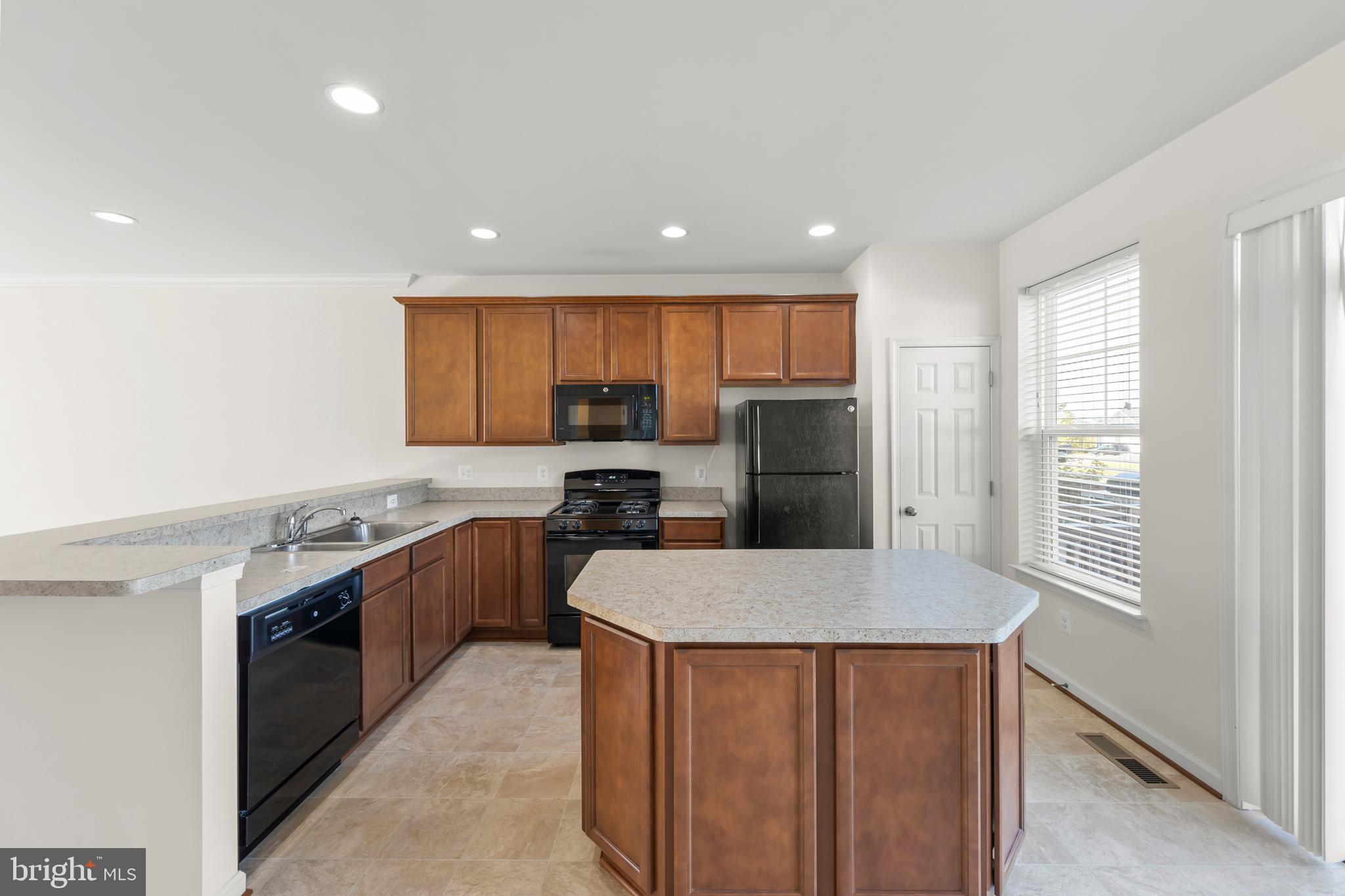107 Fading Star Court Stephenson, VA 22656 - Photo 26 of 50 a large kitchen with stainless steel appliances granite countertop a sink a stove a refrigerator a center island and a refrigerator