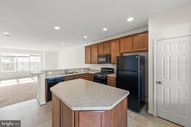 a kitchen with a stove a refrigerator and a window