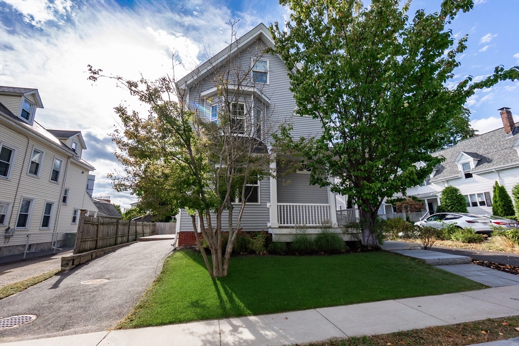 55 Phillips Street, Unit 55 Watertown, MA 02472 - Photo 1 of 15 a view of a white house next to a yard with big trees