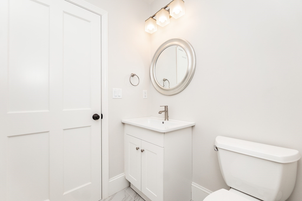 55 Phillips Street, Unit 55 Watertown, MA 02472 - Photo 12 of 15 a bathroom with a toilet a sink and a mirror