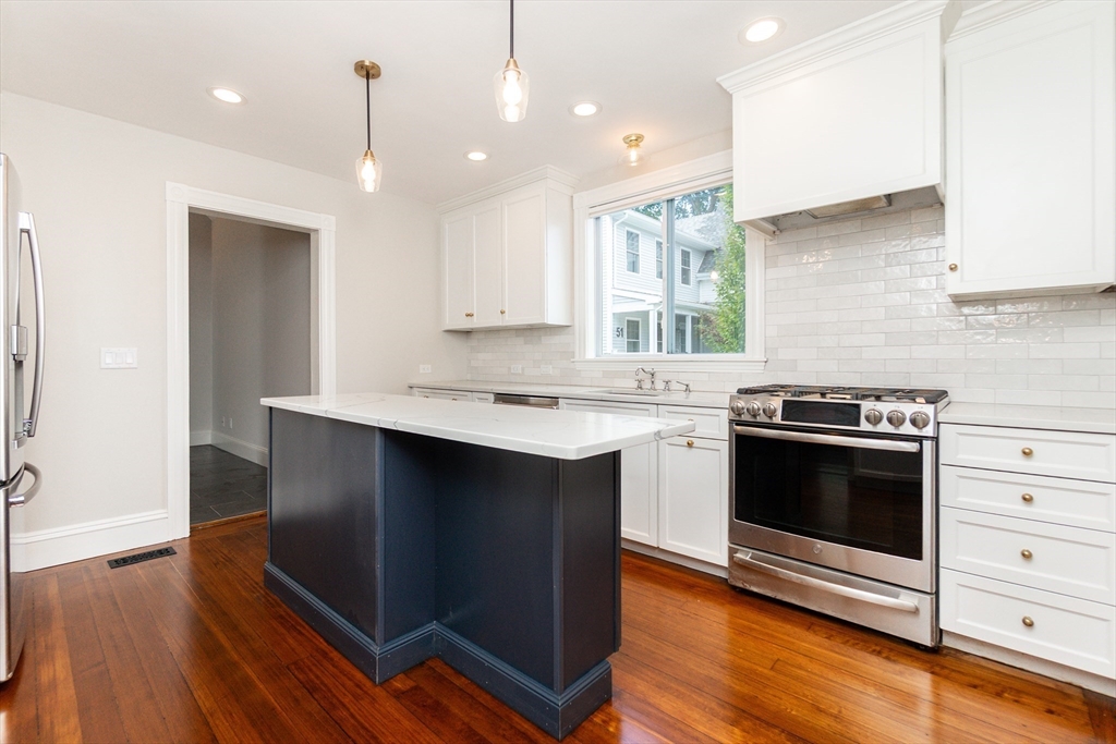 55 Phillips Street, Unit 55 Watertown, MA 02472 - Photo 2 of 15 a kitchen with granite countertop a stove a sink and a refrigerator