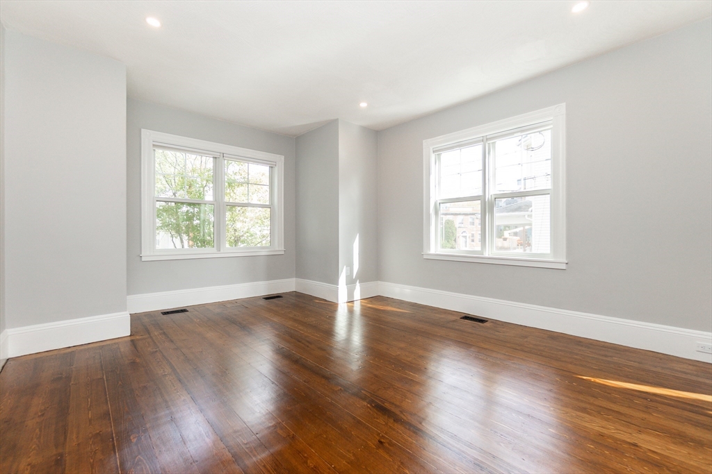 55 Phillips Street, Unit 55 Watertown, MA 02472 - Photo 3 of 15 an empty room with wooden floor and windows
