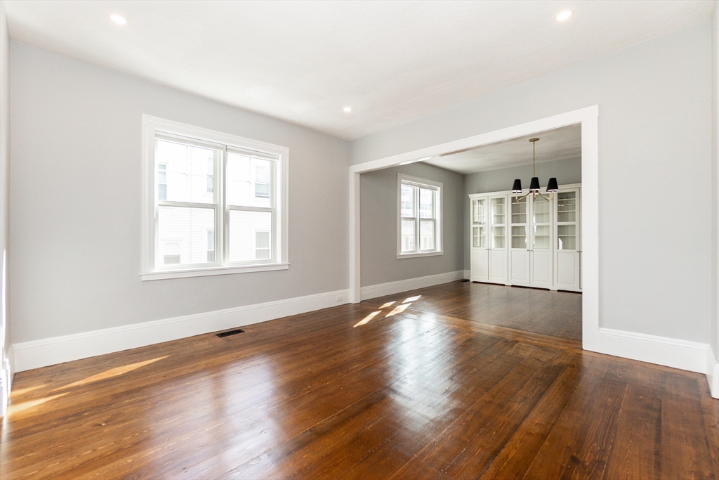 55 Phillips Street, Unit 55 Watertown, MA 02472 - Photo 4 of 15 an empty room with wooden floor and windows
