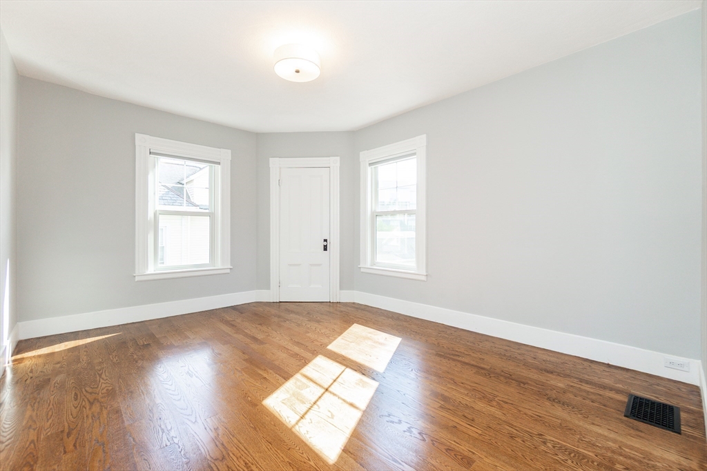 55 Phillips Street, Unit 55 Watertown, MA 02472 - Photo 9 of 15 an empty room with wooden floor and windows