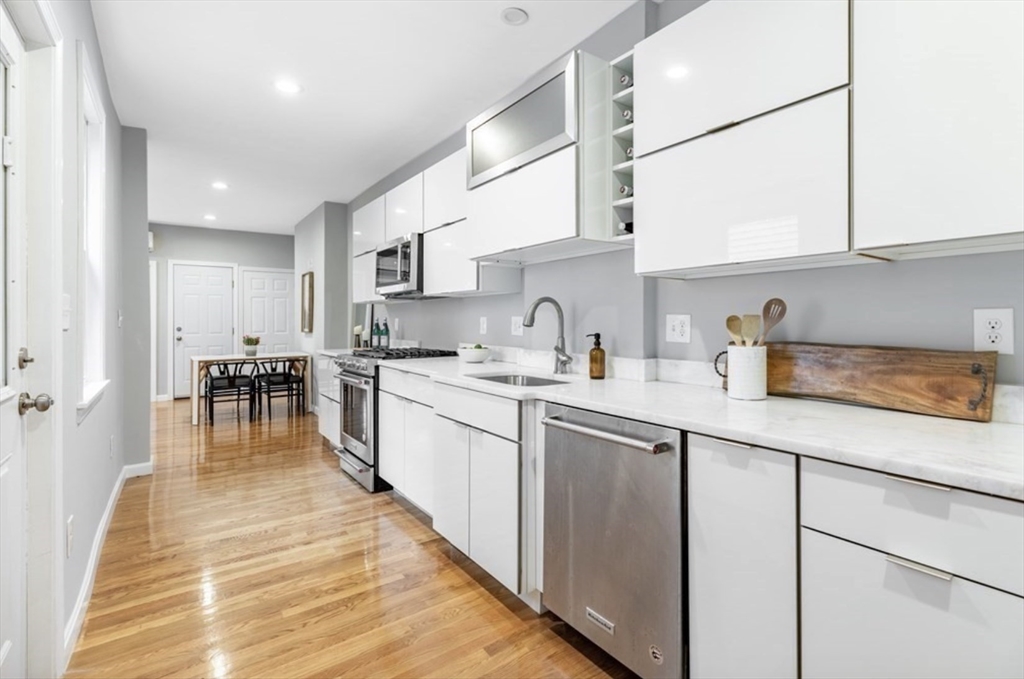 353 Sumner Street, Unit 1 Boston, MA 02128 - Photo 8 of 23 a kitchen with stainless steel appliances granite countertop a sink and cabinets