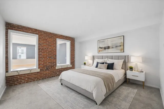 a bedroom with a bed and a large window