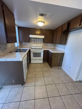 a kitchen with a sink a stove and a microwave oven