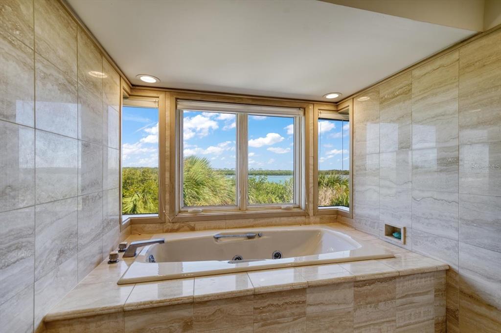 1198 Mandalay Point Road Clearwater, FL 33767 - Photo 20 of 61 a bathroom with a bathtub a window and a shower