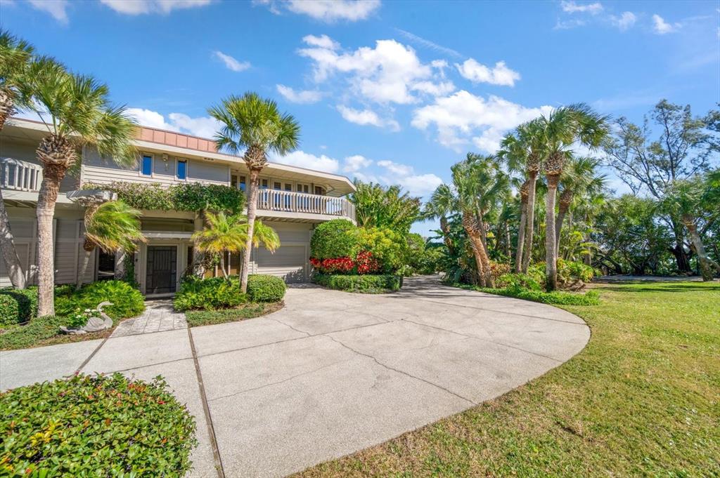 1198 Mandalay Point Road Clearwater, FL 33767 - Photo 52 of 61 a view of a big house with a big yard and potted plants