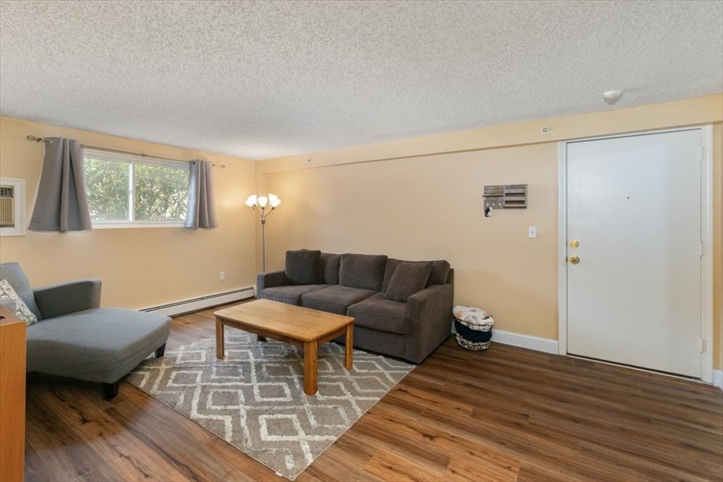 25 Clark's Road, Unit 101 Amesbury, MA 01913 - Photo 7 of 32 a living room with furniture and a wooden floor