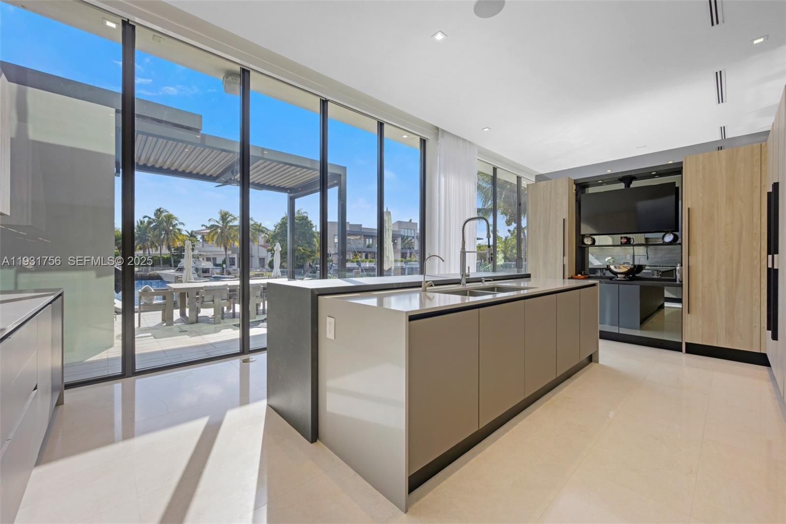 3260 Northeast 165th Street North Miami Beach, FL 33160 - Photo 14 of 43 a large kitchen with kitchen island a large window a sink and stainless steel appliances