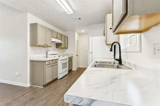 a kitchen with stainless steel appliances granite countertop a sink stove and cabinets
