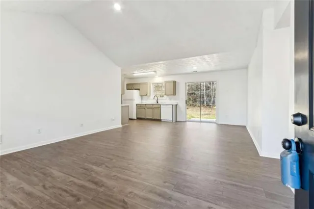 a view of empty room with wooden floor and fireplace