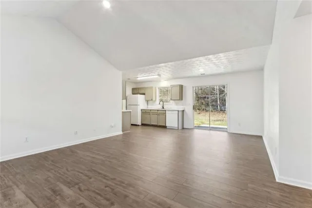 a view of empty room with wooden floor and windows