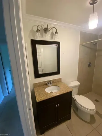 a bathroom with a granite countertop sink toilet and mirror