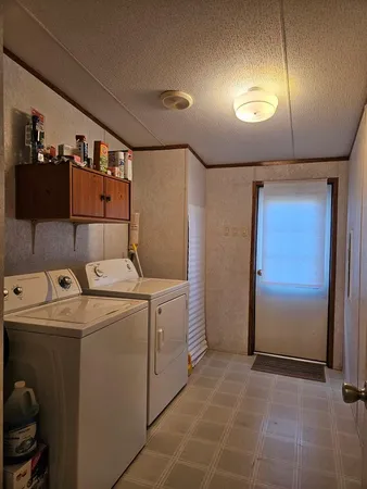 a view of storage and utility room with a fridge