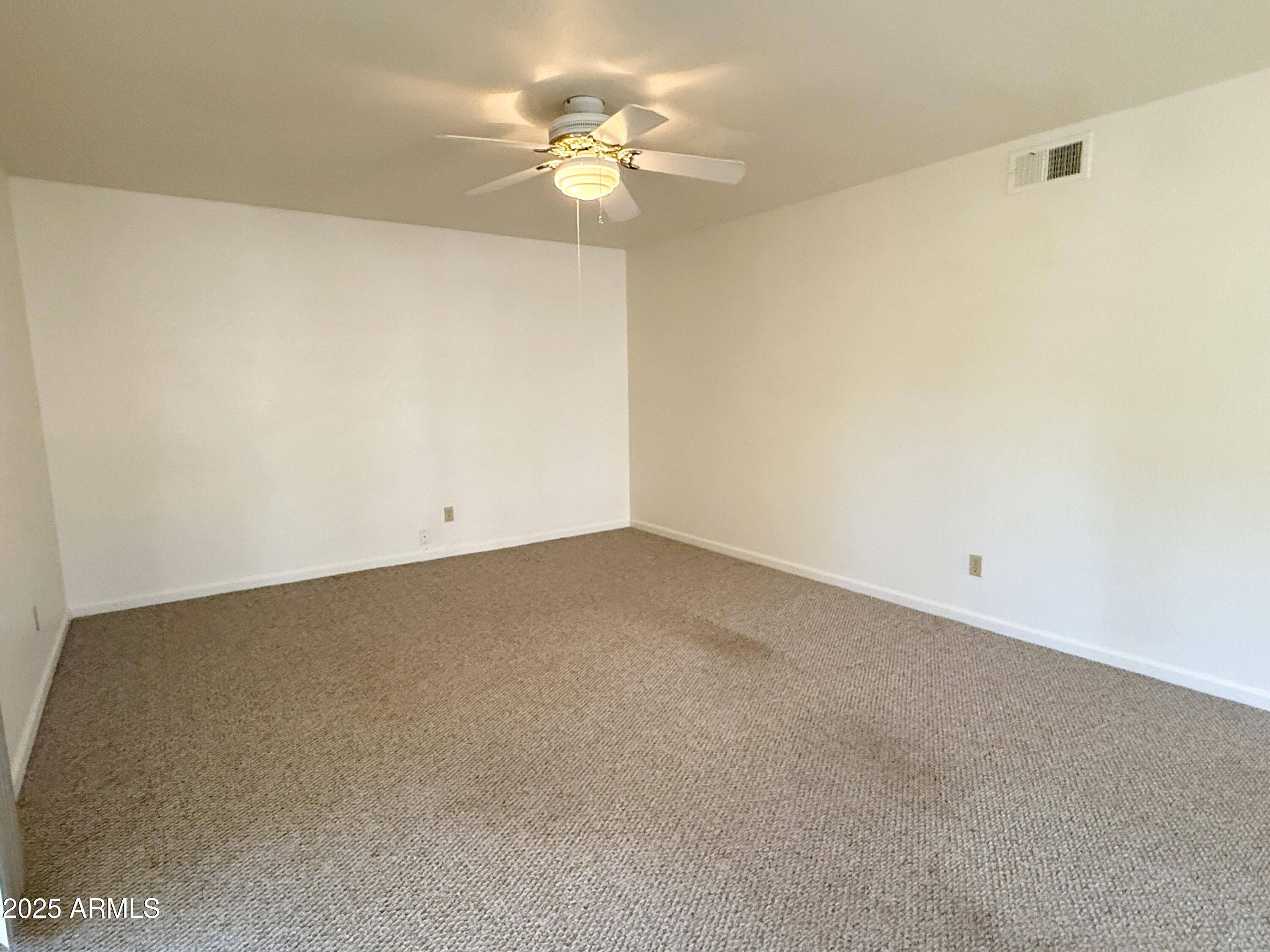 867 North Arroya Road Apache Junction, AZ 85119 - Photo 4 of 19 an empty room with a ceiling fan and a window