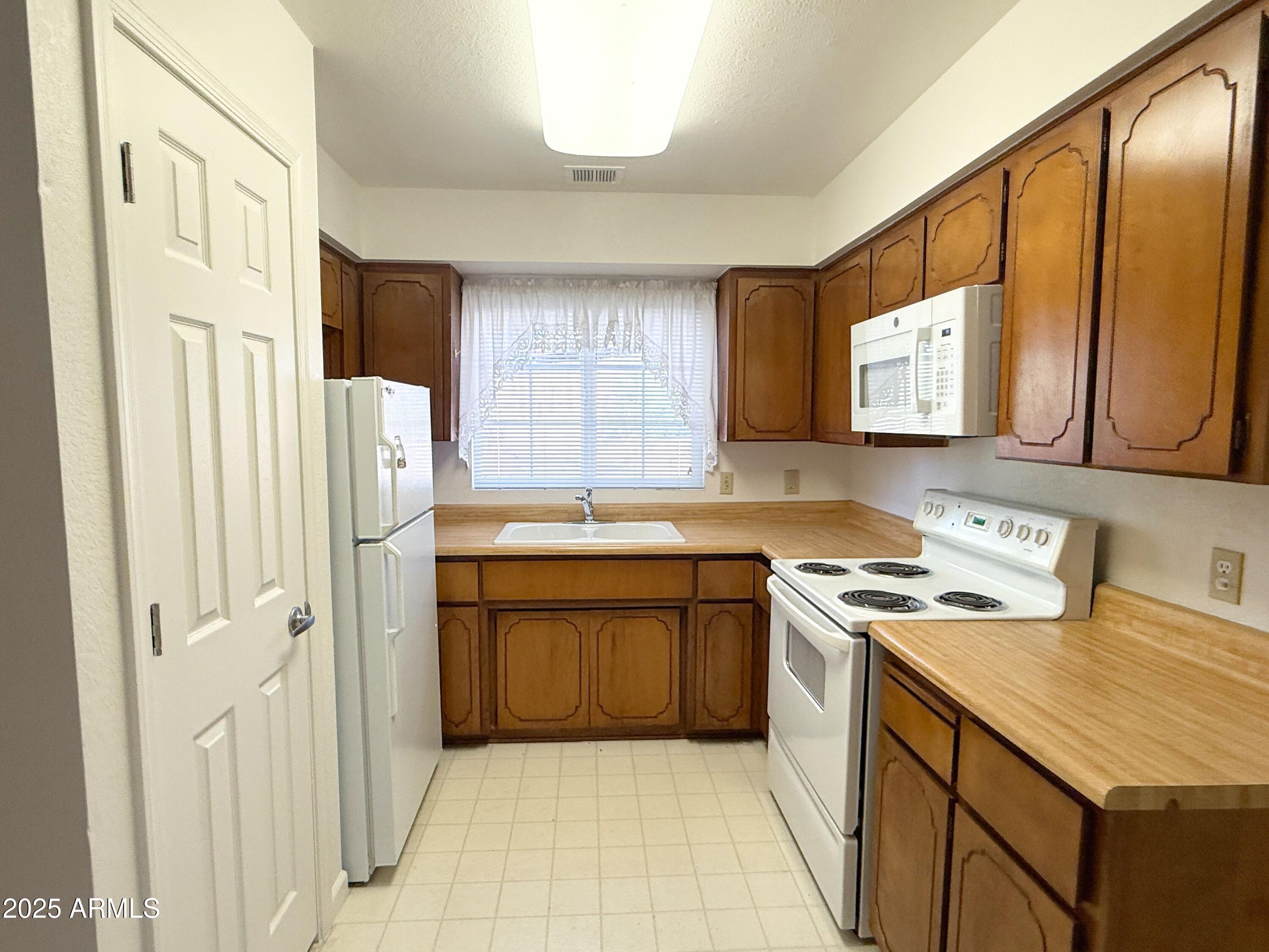 867 North Arroya Road Apache Junction, AZ 85119 - Photo 7 of 19 a kitchen with stainless steel appliances granite countertop a sink stove and refrigerator