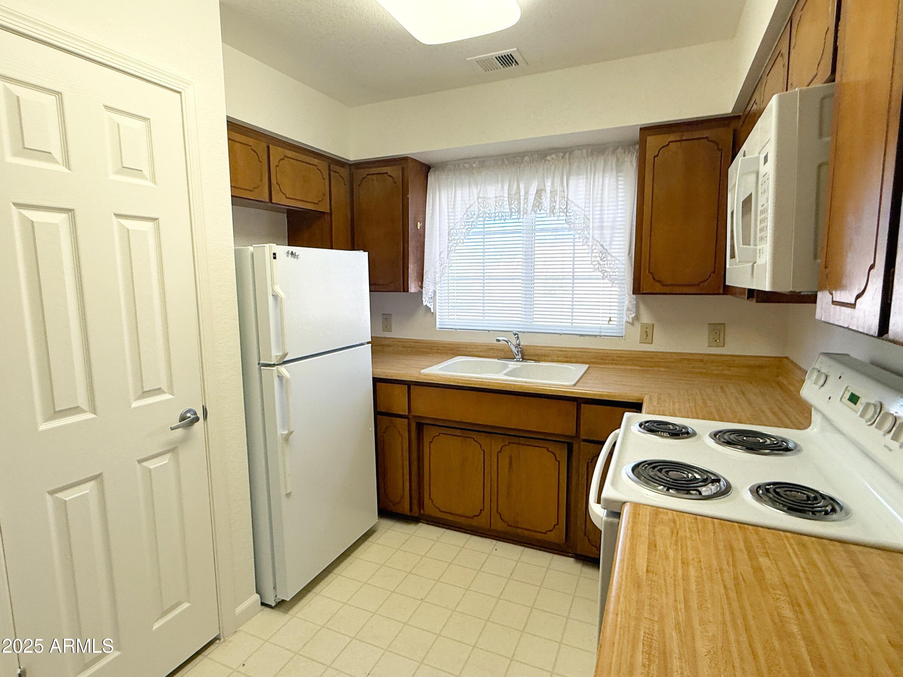 867 North Arroya Road Apache Junction, AZ 85119 - Photo 8 of 19 a kitchen with a refrigerator a stove a sink and a cabinets