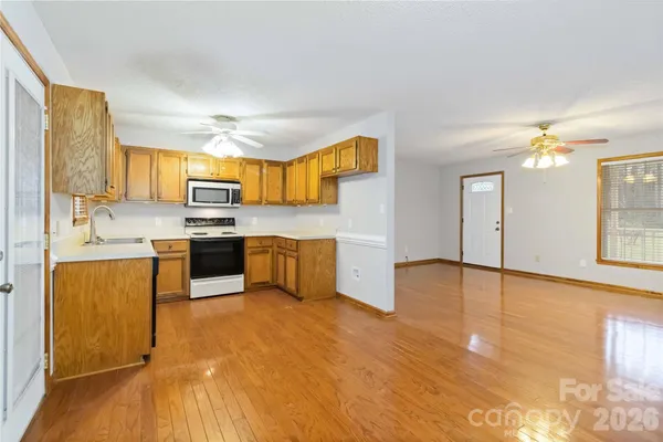 a kitchen with kitchen island granite countertop a stove top oven a sink a counter space and cabinets
