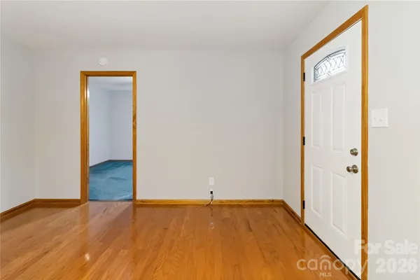a view of a room with wooden floor and a bathroom