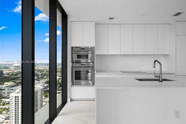 a view of a kitchen with refrigerator and windows