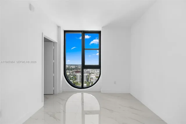 a living room with furniture a potted plant and a large window