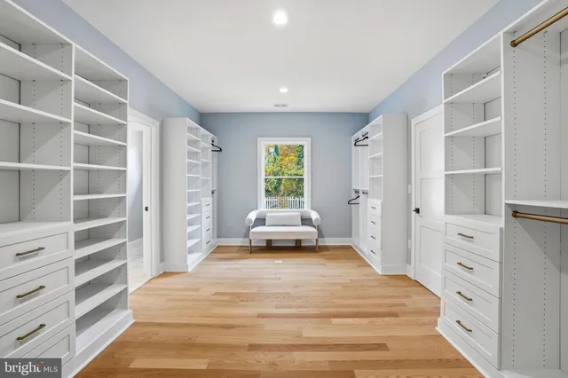 a view of an empty room with wooden floor and windows