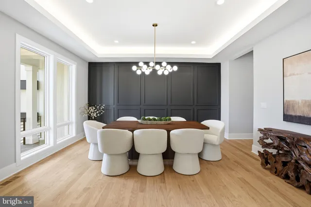 a dining room with furniture a chandelier and wooden floor