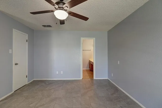 an empty room with a ceiling fan and a window