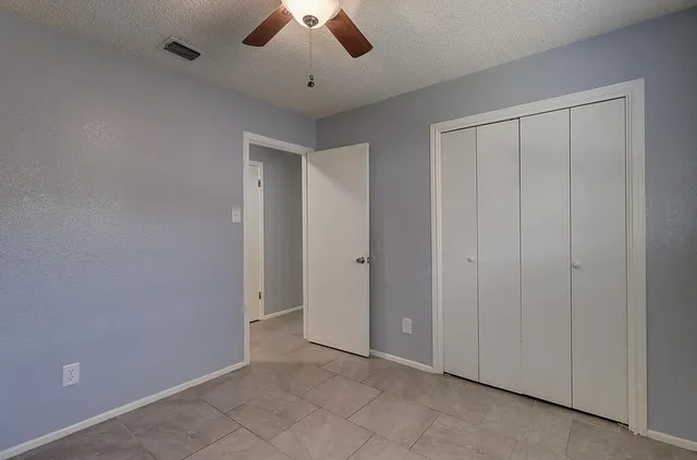 an empty room with chandelier fan