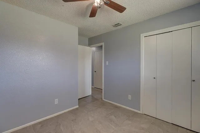 an empty room with chandelier fan