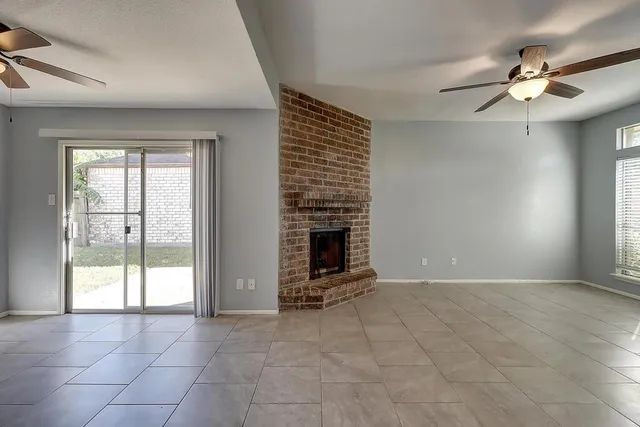 a view of an empty room with a fireplace and a window