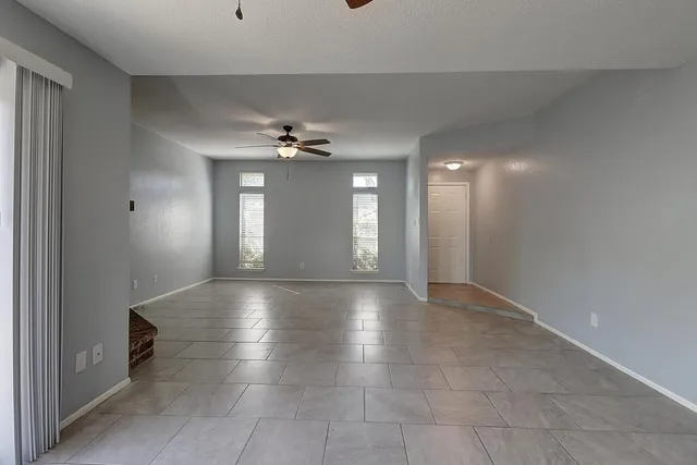 a view of an empty room with a chandelier fan