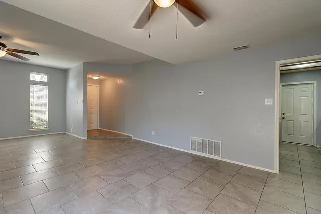 an empty room with fan and windows
