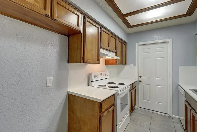 a kitchen with a stove cabinets and a refrigerator