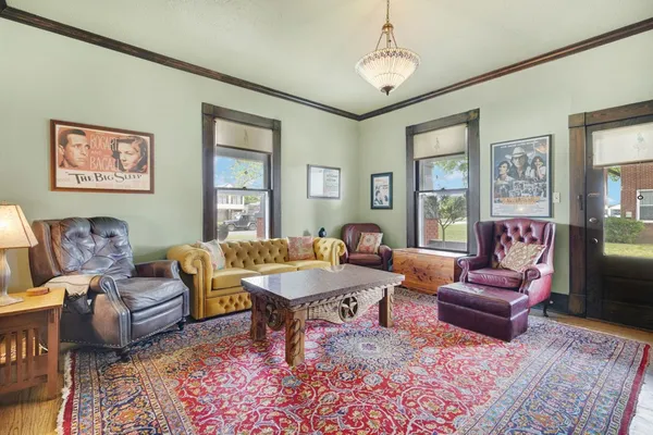 a living room with furniture wooden floor and a chandelier