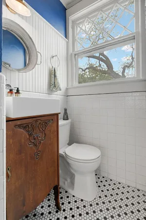 a bathroom with a sink a toilet and a mirror