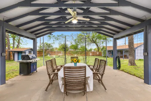 a view of a patio with couches chairs dining table and chairs with wooden floor