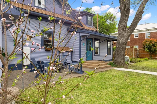 a view of a house with backyard and sitting area