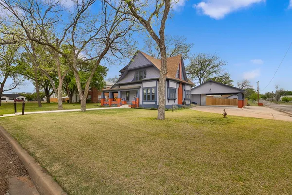 a yellow house with trees in front of it