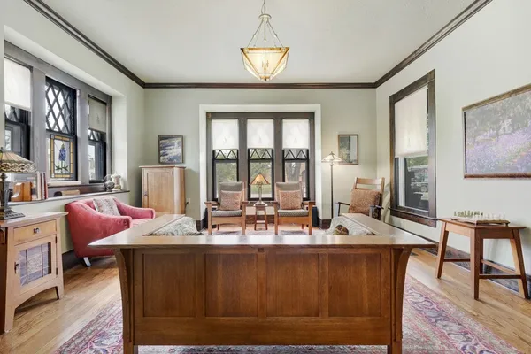 a room with wooden floor table and chairs